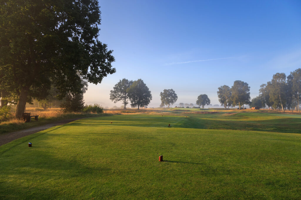A tee looking down a heathland hole in early-morning mist at Fulford Golf Club, York