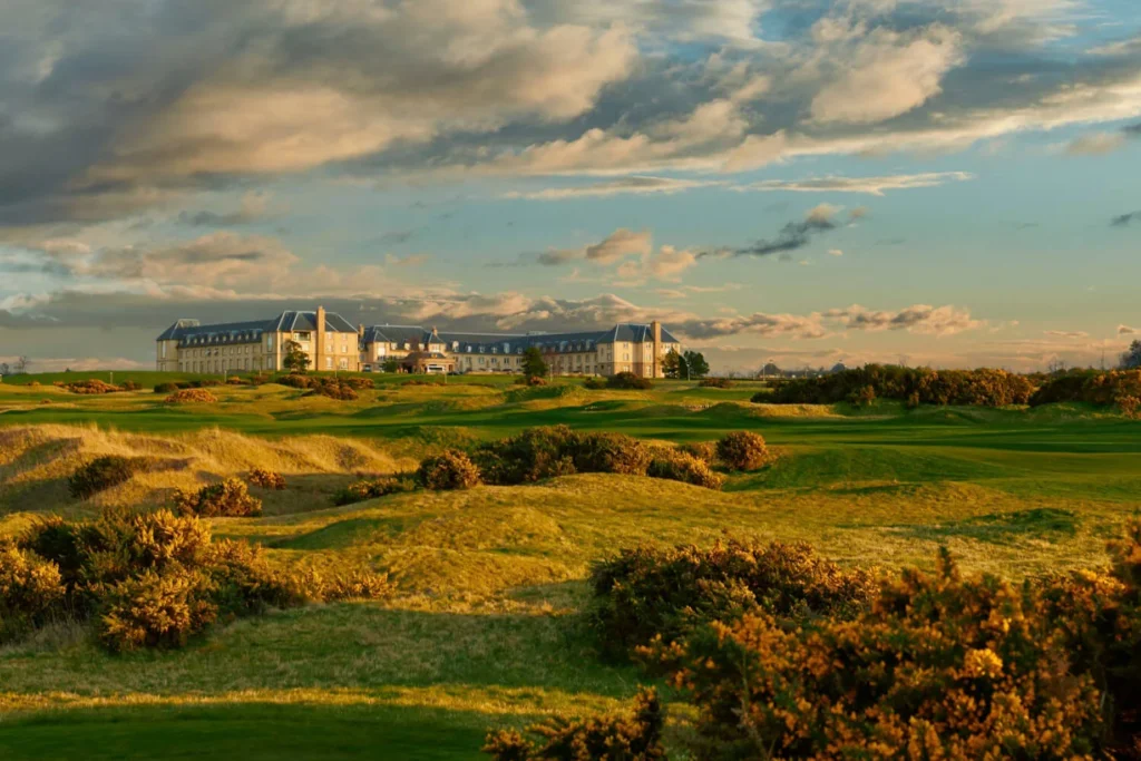 Fairmont St Andrews hotel above gorse-lined links at sunset