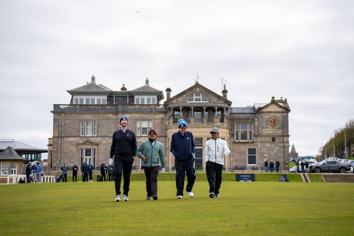 A fourball walking off the 1st tee of the Old Course in front of the R&A clubhouse, St Andrews